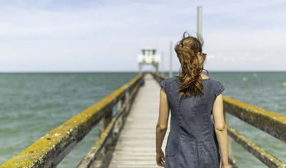 Femme marchant sur la jetée à Luc-sur-mer