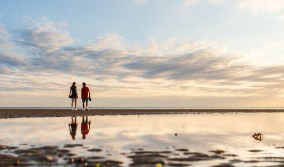 Couple se baladant sur la plage au coucher du soleil 