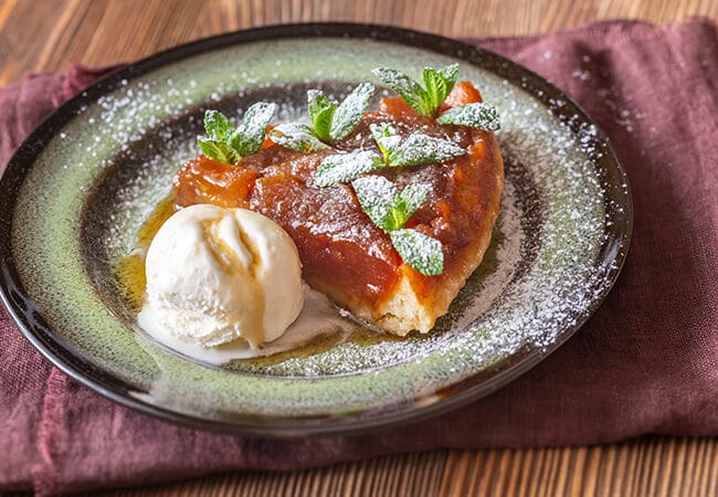 Part de tarte tatin avec une boule de glace vanille